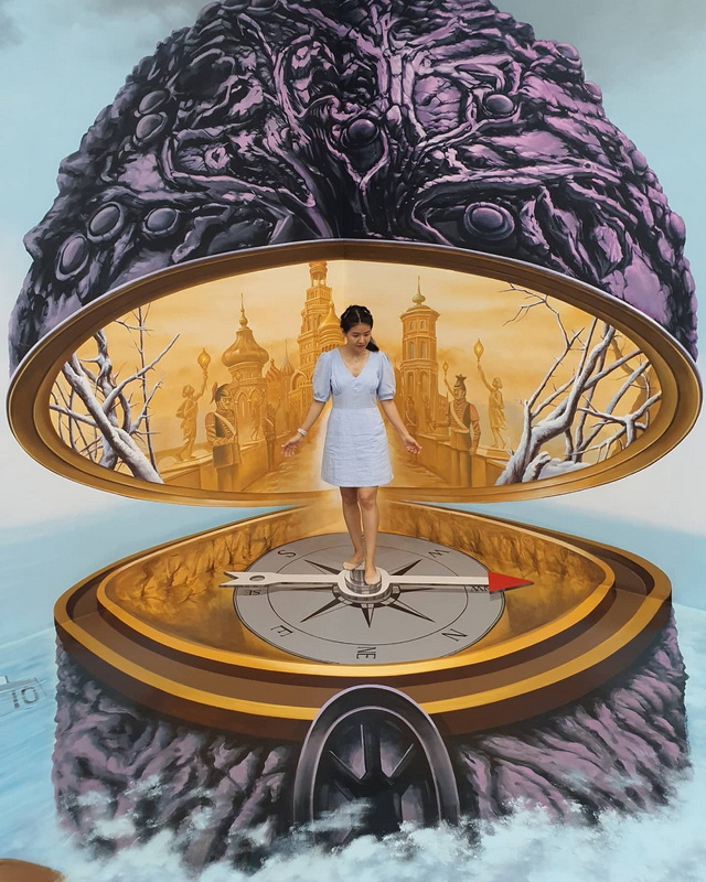 Surreal Art Installation at Chiang Mai Art in Paradise Woman standing on a compass inside an artistic structure with castle backdrop and textured top at Chiang Mai Art in Paradise.