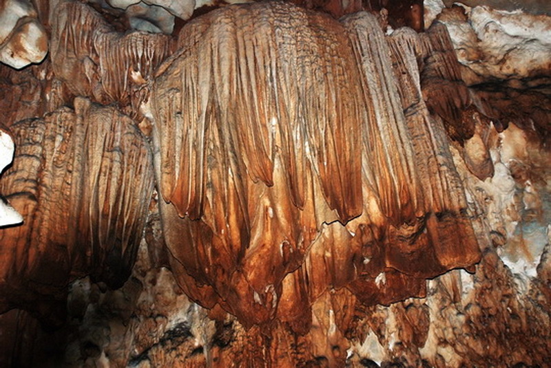 Close-up view of cave formations with dripping stalactites and mineral deposits at Tham Chiang Dao.