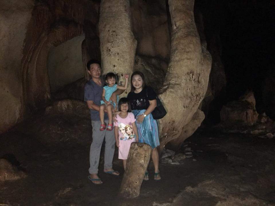 Family in Cave Interior at Chiang Dao Cave Family posing inside a dark cave with large rocks and formations behind them at Chiang Dao Cave.