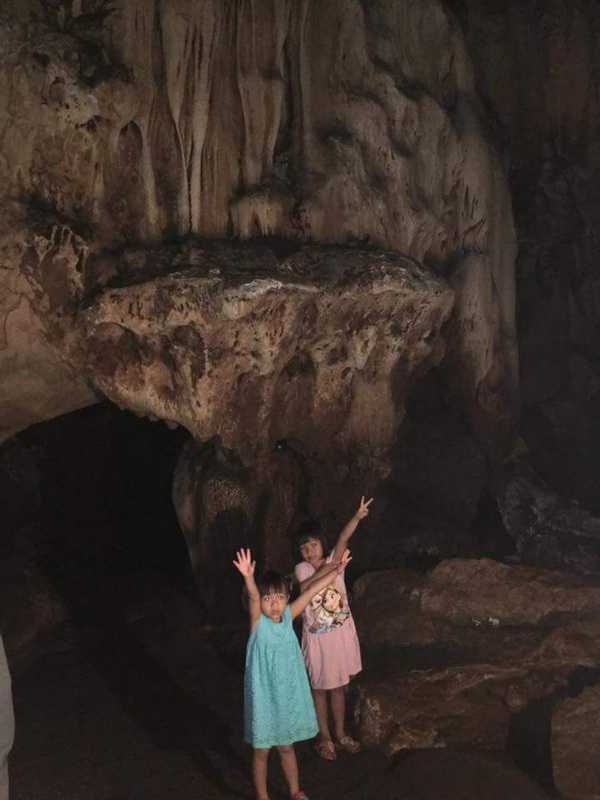 Children Inside a Cave at Chiang Dao Cave Two children posing inside a dark cave with large rocks and an opening behind them at Chiang Dao Cave.