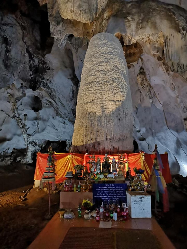 Cave Altar with Stalagmite at Muang On Cave Large stalagmite with offerings and decorations inside a cave at Muang On Cave.