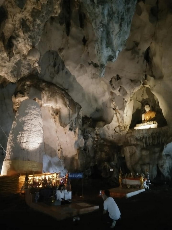 Cave Interior with Buddha Statue at Mueang On Cave Interior view of a cave with a large Buddha statue and illuminated figures at Mueang On Cave.