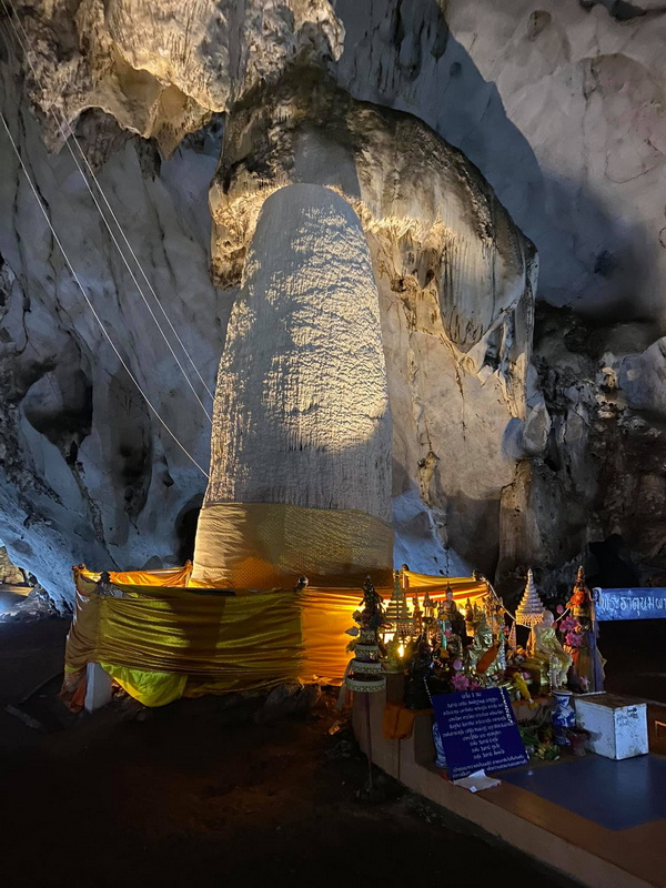 Inside Mueang On Cave Large illuminated stalagmite inside a cave with altar and decorations at the base at Mueang On Cave.