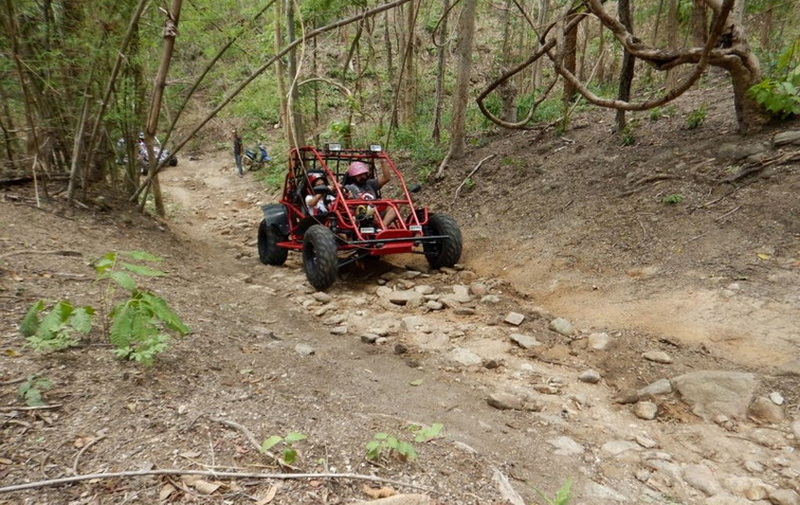 Forest ATV Adventure at Chiang Mai atv tour Two riders in a red ATV navigating a rocky forest trail at Chiang Mai atv tour.