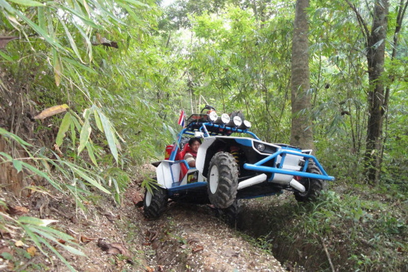 Off-Road Vehicle in Forest at ATV tour Chiang Mai Child riding in a blue and white off-road vehicle on a forest trail at ATV tour Chiang Mai.