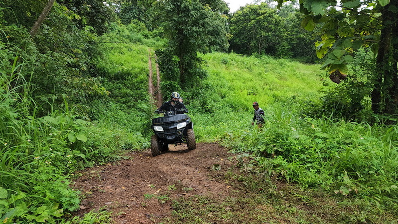 Person on ATV riding on a dirt trail through lush green forest at Chiang Mai atv tour.
