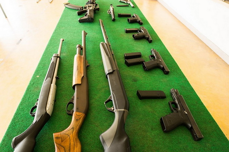 Firearms Display on Green Table at Chiang Mai Shooting Club Group of rifles and handguns laid out on a green surface in a shooting range or club setting at Chiang Mai Shooting Club.