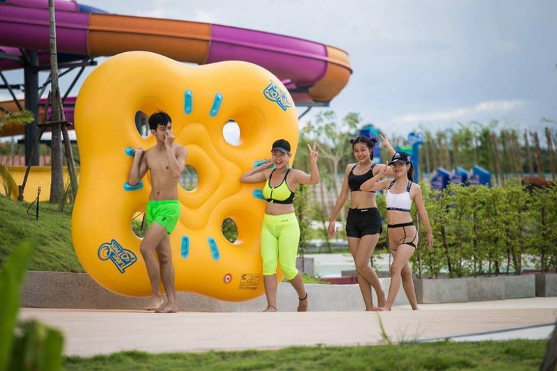 Water Park Fun with Friends at Tube Trek Water Park Group of four people enjoying at a water park near a flotation device and water slide at Tube Trek Water Park.