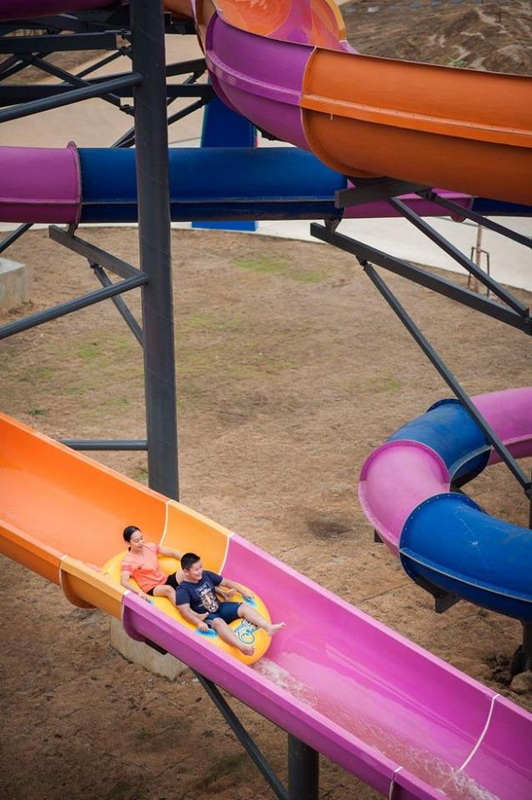 Children riding a yellow and blue tube on a pink water slide at the water park at Tube Trek Water Park.
