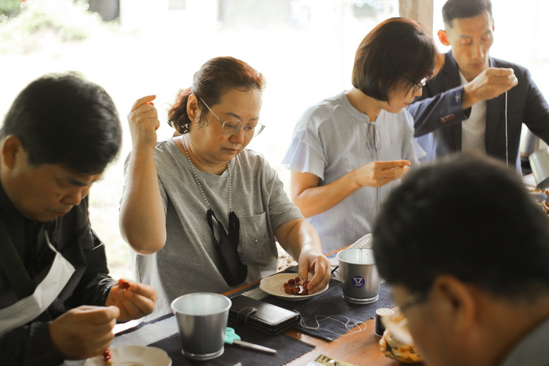 People sitting at a table enjoying food indoors with a bright window behind them at Coffee Farm Tour Chiang Mai.