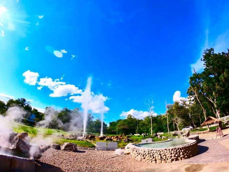 Relaxing Hot Springs Scene at San Kamphaeng Hot Springs Hot springs with fountains and steam under a clear blue sky surrounded by trees at San Kamphaeng Hot Springs.