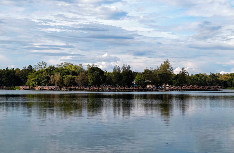 Serene lake with trees along the shore and reflections on the water surface at Huay Tung Tao.