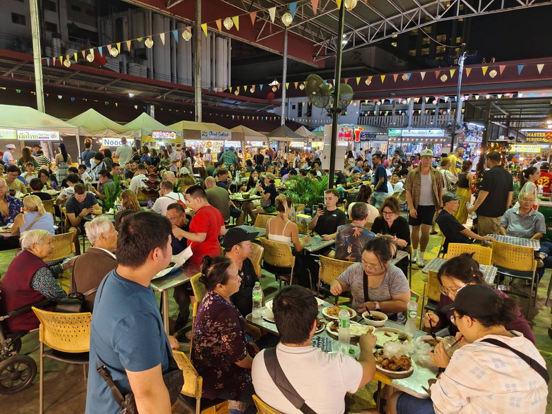 Indoor Market Gathering at Best Night Markets In Chiang Mai Crowded indoor market with people dining and colorful decorations overhead at Best Night Markets In Chiang Mai.