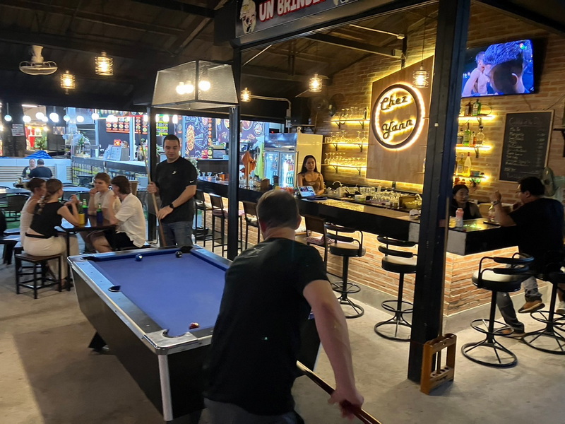 Indoor Bar Scene with Pool Table at Chiang Mai Night Market Food Guide People enjoying pool game and drinks inside a modern bar setting at Chiang Mai Night Market Food Guide.