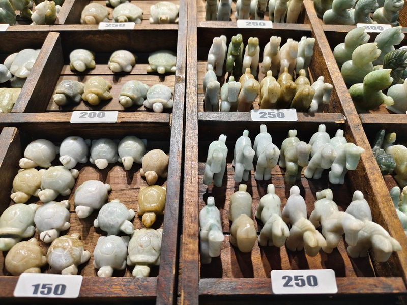 Stone Figurines Display at Chiang Mai Night Market Shopping Small stone figurines displayed in wooden compartments with price labels at Chiang Mai Night Market Shopping.