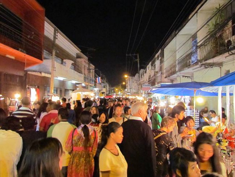 A busy night market street filled with people and food stalls at night at Wua Lai Walking Street Chiang Mai.