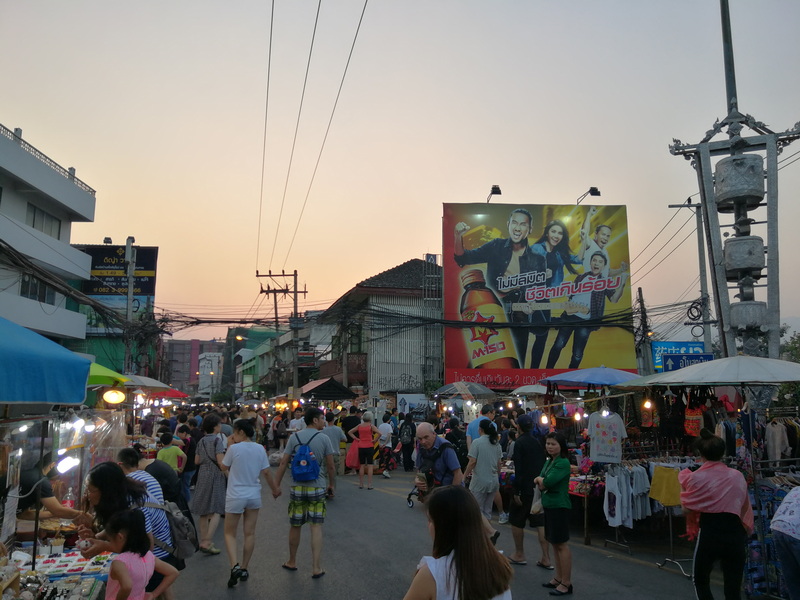 Vibrant Market at Sunset at Wua Lai Walking Street Chiang Mai Busy market street with vendors, shoppers, and colorful umbrellas at dusk at Wua Lai Walking Street Chiang Mai.