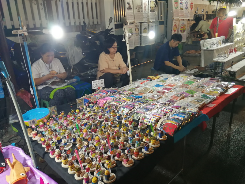 Indoor Market Craft Stall at Saturday Walking Street Chiang Mai Women sit at a table with colorful crafts at an indoor market stall at Saturday Walking Street Chiang Mai.