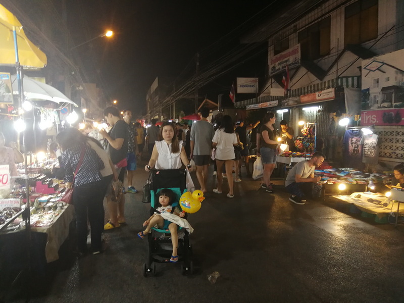Night Market Scene at Saturday Walking Street Chiang Mai Night street market with vendors and shoppers illuminated by lights at Saturday Walking Street Chiang Mai.