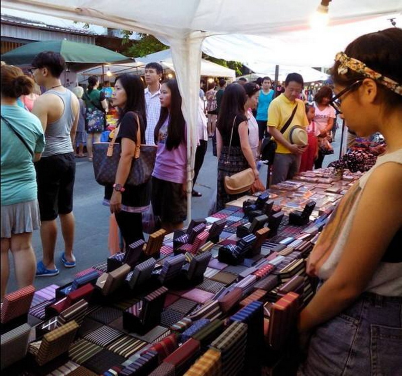 Night Market Shopping Scene at Sun Day Walking Street Chiang Mai People shopping at fabric stalls in a busy night market scene at Sun Day Walking Street Chiang Mai.