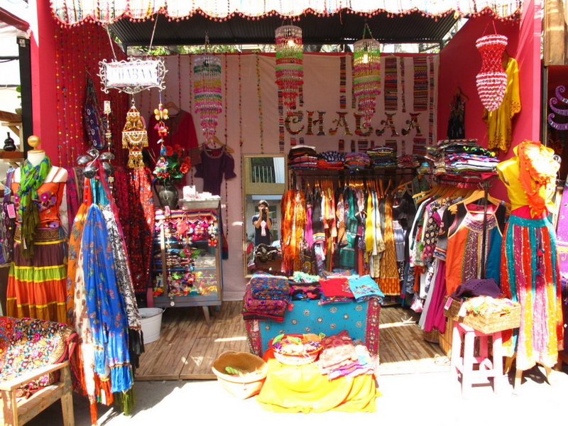 Market stall filled with colorful clothes and accessories, with a mirror in the center at Nimmanhaemin road.