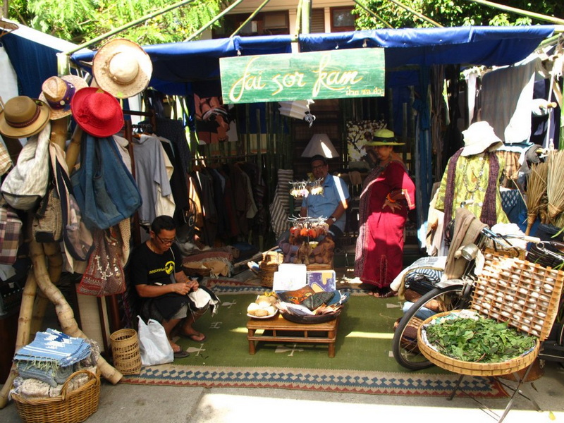 Market Stall with Hats and Bags at Nimmanhaemin road Market stall selling hats, bags, and clothes with people browsing and working at Nimmanhaemin road.