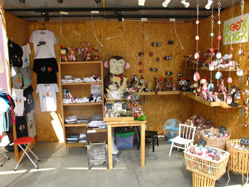 Indoor shop with plush toys, clothing, and accessories on wooden shelves and tables at Nimmanhaemin road.