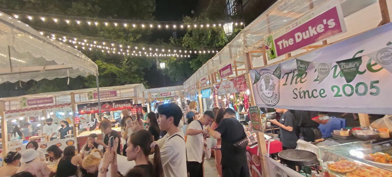 Vibrant Night Market Scene at Chiang Mai Local Markets Guide Night scene of a busy market with food stalls and shoppers under string lights at Chiang Mai Local Markets Guide.