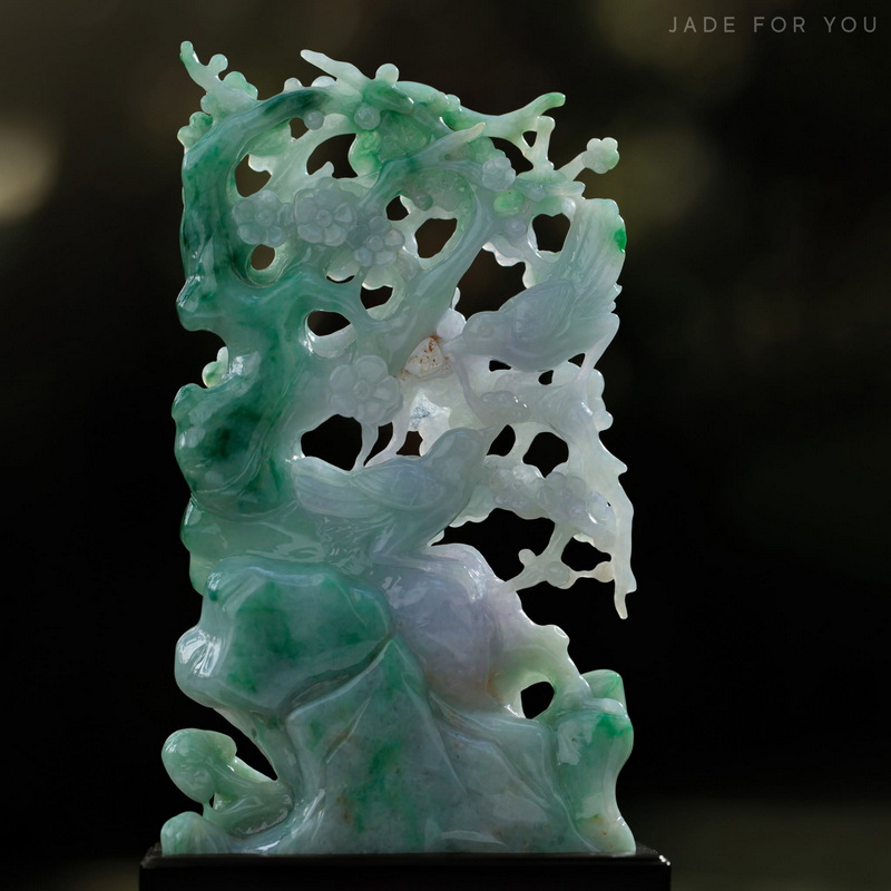 Close-up of a detailed jade sculpture with floral and animal designs at Chiang Mai Jade Factory.
