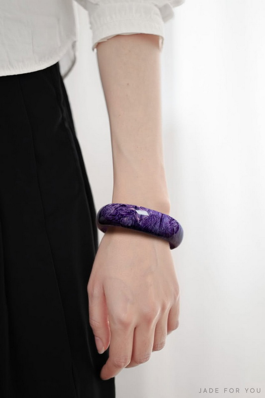 Elegant Purple Bangle Accessory at Chiang Mai Jade Factory Close-up of a person's arm wearing a purple bangle bracelet with white shirt and black pants at Chiang Mai Jade Factory.