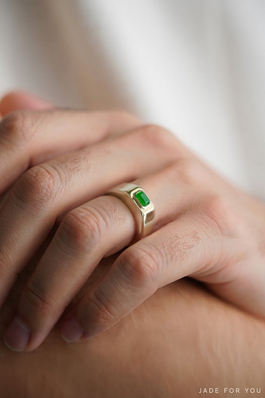 Close-up of hands with a silver ring with a green gemstone touching each other at Orchid Jade Factory.