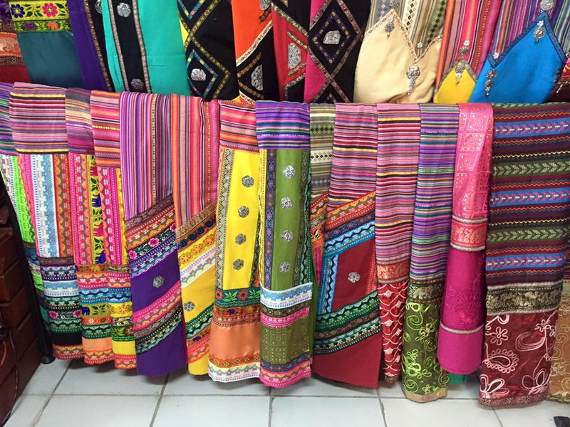 Colorful Market Textiles Display at Warorot Market Close-up of vibrant, woven fabrics with intricate patterns hanging in a market stall at Warorot Market.