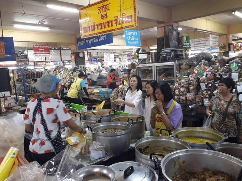 Indoor Market Scene at Souvenir Shopping Chiang Mai People shopping and cooking at a busy indoor market with large food pots at Souvenir Shopping Chiang Mai.