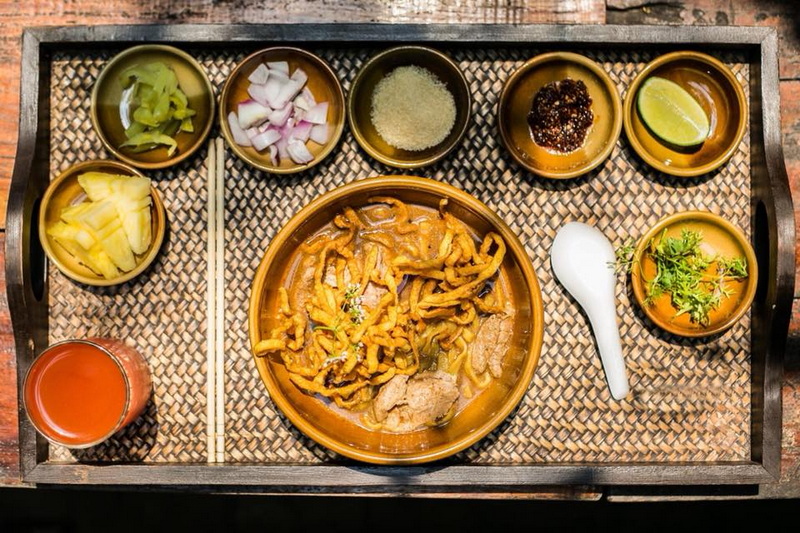 Thai Noodle Meal at Chiang Mai Cruise To Wiang Kum Kam Traditional Thai noodle dish with condiments and fresh herbs on a woven tray at Chiang Mai Cruise To Wiang Kum Kam.