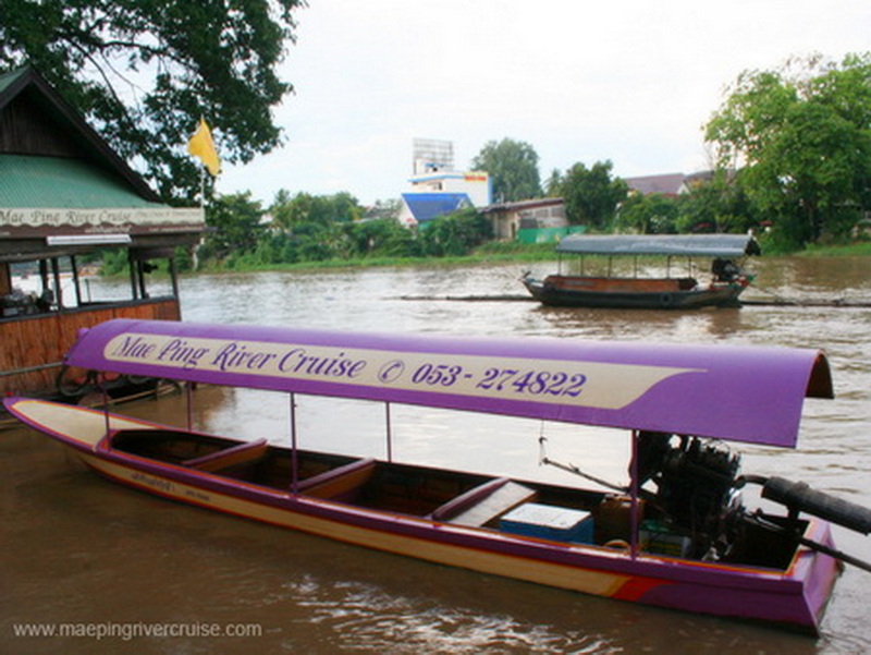 A purple river boat with canopy on the water, with another boat in the background at Chiang Mai Cruise To Wiang Kum Kam.