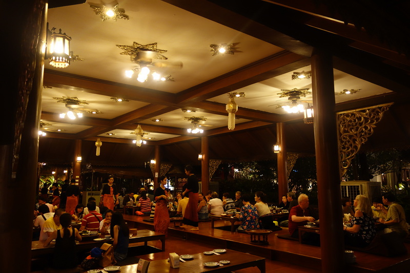 People dining at tables in a warmly lit indoor restaurant setting at Khantoke.