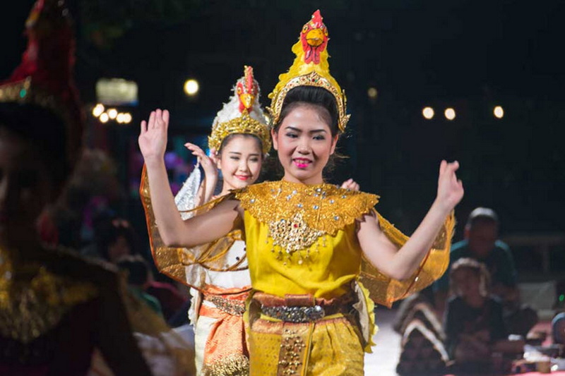 Traditional Dance Performance at Khantoke Two women dancing in traditional costumes during a night festival scene at Khantoke.