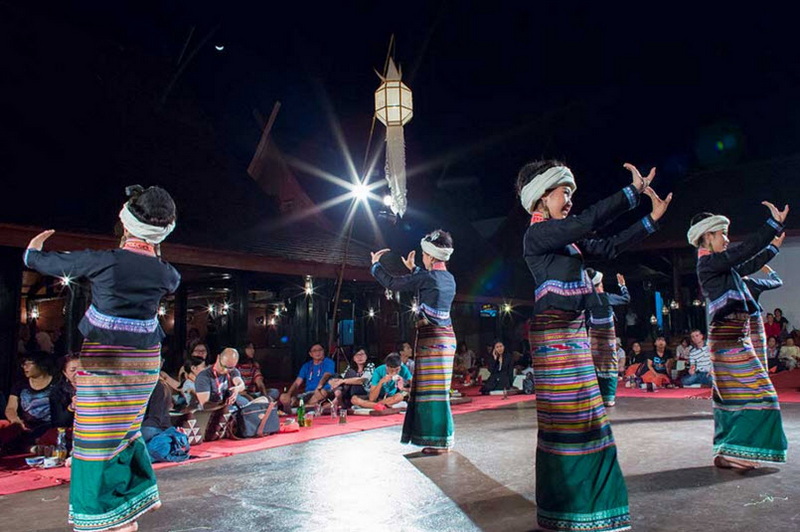 Traditional Dance Performance at Old Chiangmai Cultural Center Khantoke Women perform traditional dance in colorful skirts during a cultural event at night at Old Chiangmai Cultural Center Khantoke.