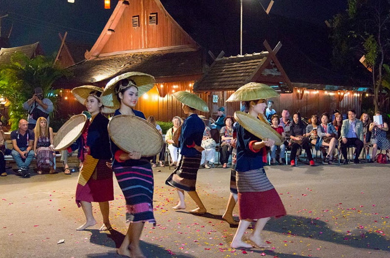 Traditional Dance Performance at Night at Old Chiangmai Cultural Center Women in traditional clothes performing dance at night with audience watching at Old Chiangmai Cultural Center.