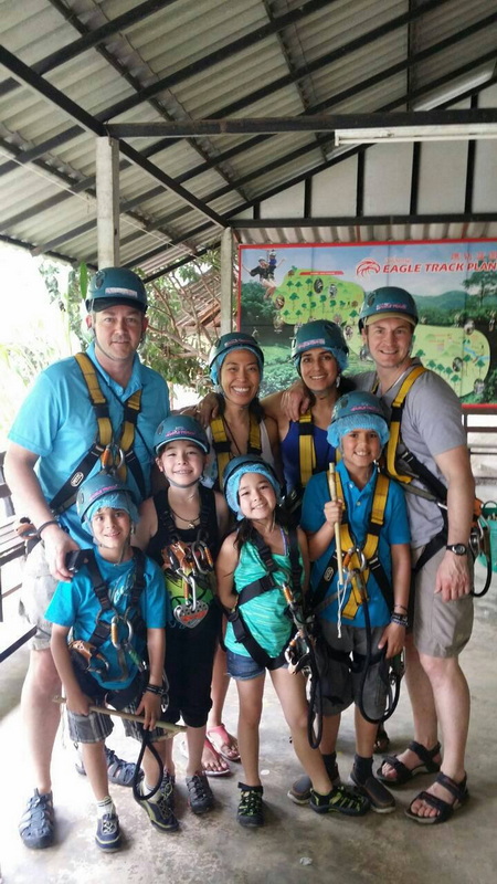 Group Ready for Adventure at Phoenix Adventure Park Children and adults wearing helmets and harnesses indoors with a colorful map behind them at Phoenix Adventure Park.