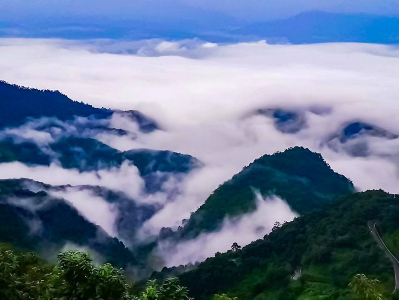 Misty Mountain Range at Doi Ang Khang Mountain peaks covered in fog and lush greenery under a cloudy sky at Doi Ang Khang.