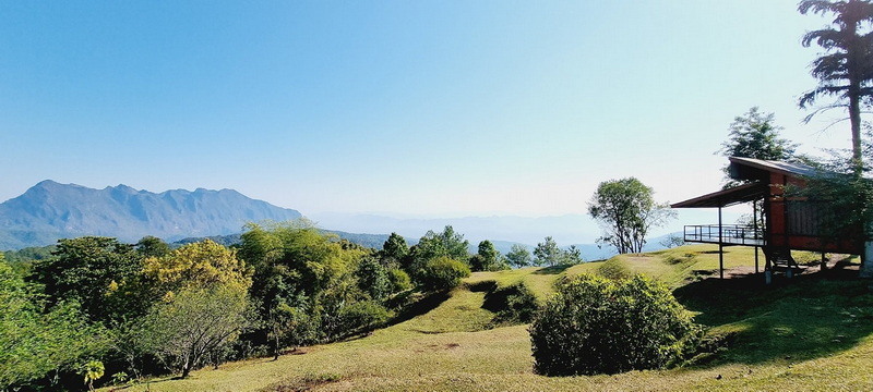 View of Chiang Dao Mountains at Doi Luang Chiang Dao Scenic view of Chiang Dao mountains with trees and a house in the foreground at Doi Luang Chiang Dao.