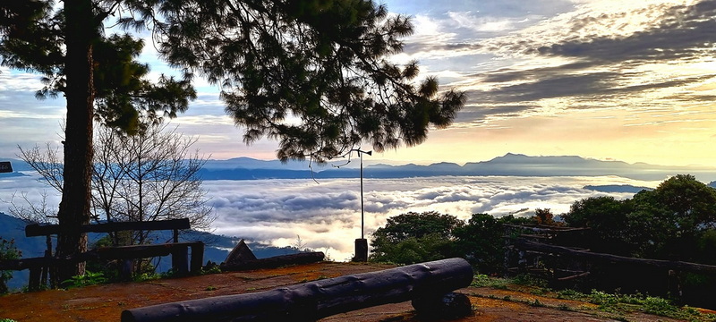 Scenic Mountain View at Doi Luang Chiang Dao Mountain viewpoint with clouds below and sunset sky in the distance at Doi Luang Chiang Dao.