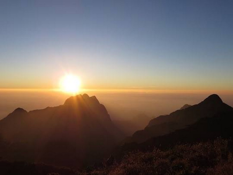 Sunrise Over Mountain Peaks at Doi Luang Chiang Dao Sunrise over mountain peaks with a clear sky and layered clouds at Doi Luang Chiang Dao.
