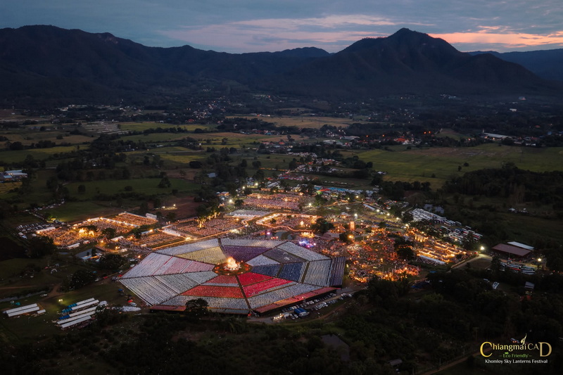 Chiang Mai Lantern Festival at New Year Countdown Chiang Mai by CAD Aerial view of a festival with colorful lights and mountains in the background during dusk at New Year Countdown Chiang Mai by CAD.
