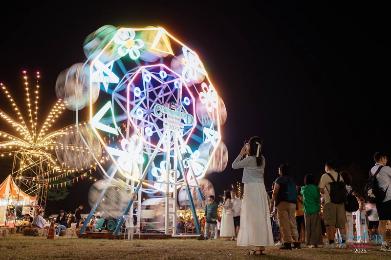 People watching and taking photos of the illuminated Ferris wheel at night at Chiang Mai New Year Countdown 2027 by CAD.