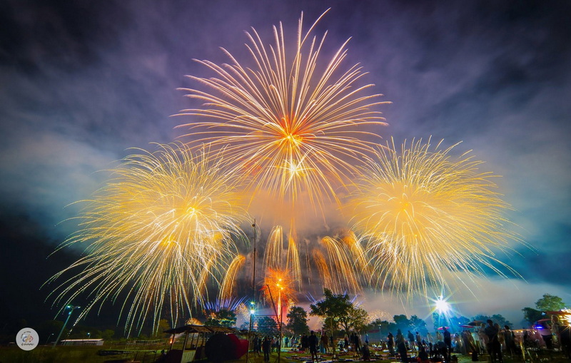 Night Fireworks Celebration at New Year Countdown Chiang Mai by CAD Bright fireworks explode in the night sky during a celebration with a crowd below at New Year Countdown Chiang Mai by CAD.