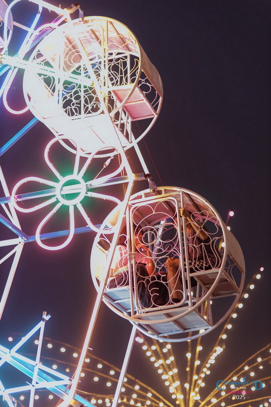 Nighttime Ferris Wheel Ride at Chiang Mai New Year Countdown 2027 by CAD Children enjoying rides in Ferris wheel cabins illuminated with colorful lights at night at Chiang Mai New Year Countdown 2027 by CAD.