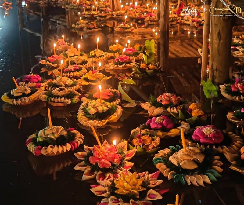 Flower-shaped offerings with lit candles floating on water during a celebration at Yi Peng Chiang Mai.