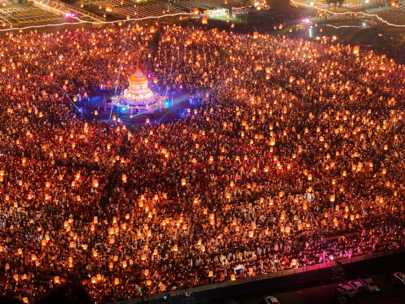 Crowd holding lanterns during a nighttime festival setting in Chiang Mai at Yi Peng Chiang Mai.